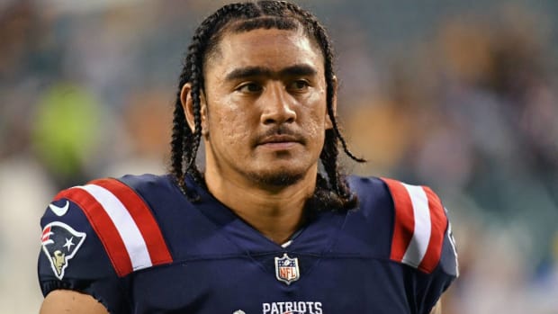 Patriots tight end Devin Asiasi looks on without a helmet during a game.